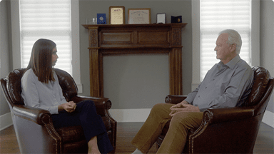 A female journalist interviewing Professor Walter Balle in his house.